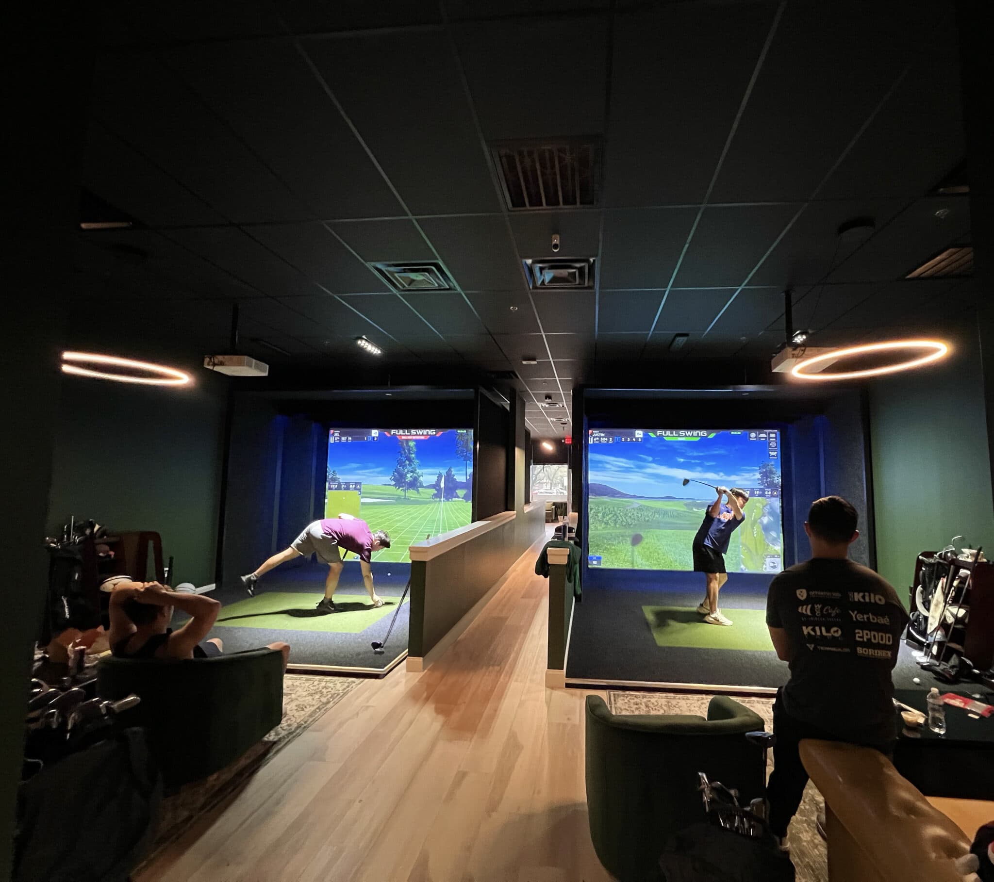 Golfers playing side-by-side Full Swing simulator bays at Rev's Golf Lounge in Highland Village, Texas
